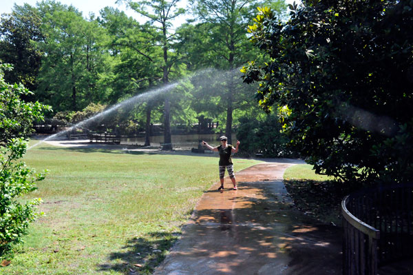 Karen Duquette getting wet under the sprinkler 
